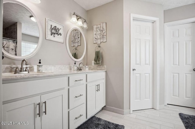 1177 Roberts Rd, Newport, NC 28570 - bathroom featuring a textured ceiling, double vanity, and baseboards