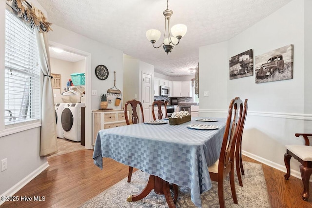 1177 Roberts Rd, Newport, NC 28570 - dining space with separate washer and dryer, a textured ceiling, a chandelier, wood finished floors, and baseboards