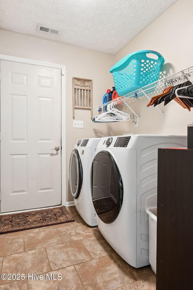 1177 Roberts Rd, Newport, NC 28570 - clothes washing area featuring washing machine and dryer, a textured ceiling, and light stone finish flooring