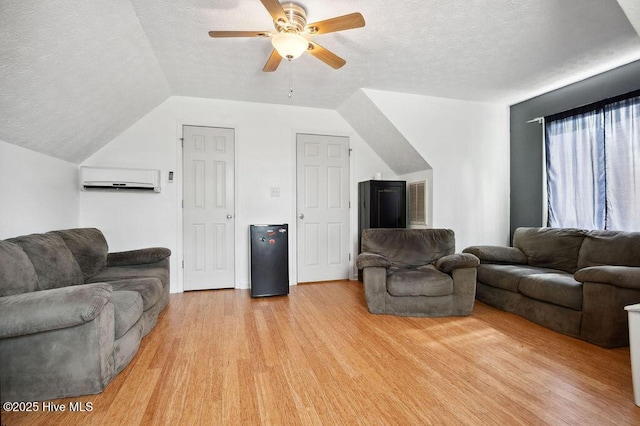 1177 Roberts Rd, Newport, NC 28570 - living room featuring ceiling fan, a textured ceiling, light wood-style floors, a wall unit AC, and vaulted ceiling