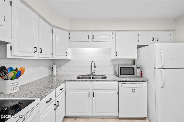 kitchen with white appliances, a sink, and white cabinetry