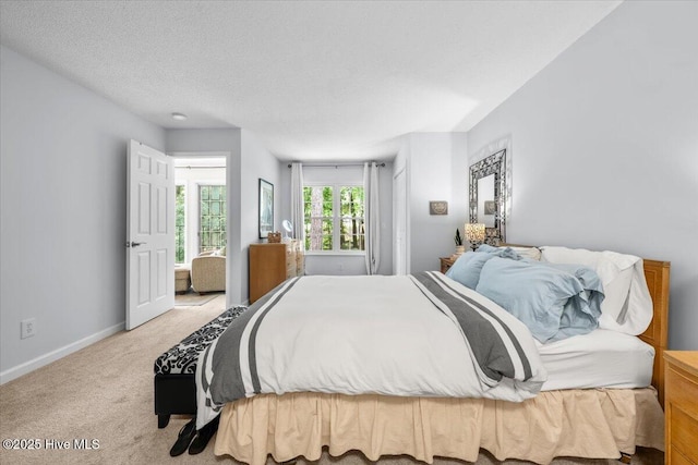 carpeted bedroom with baseboards and a textured ceiling