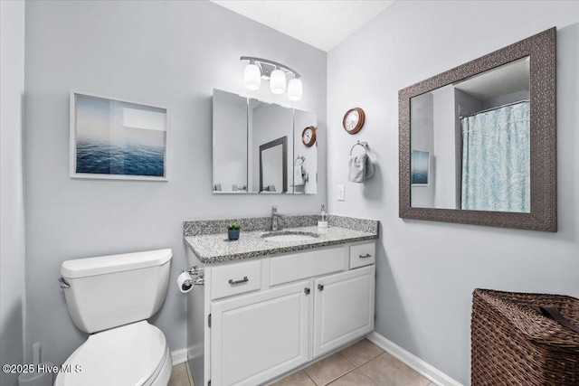 full bath with toilet, baseboards, tile patterned floors, and vanity
