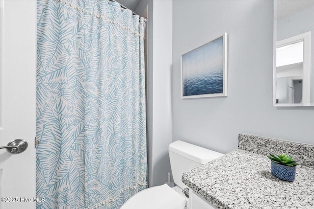 bathroom featuring toilet, a textured ceiling, and a shower with curtain