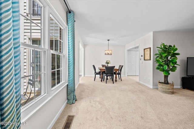 carpeted dining area featuring baseboards