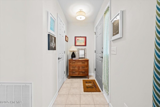doorway to outside featuring light tile patterned floors and baseboards
