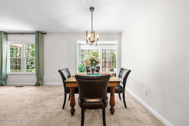 dining room featuring a chandelier, carpet, and baseboards