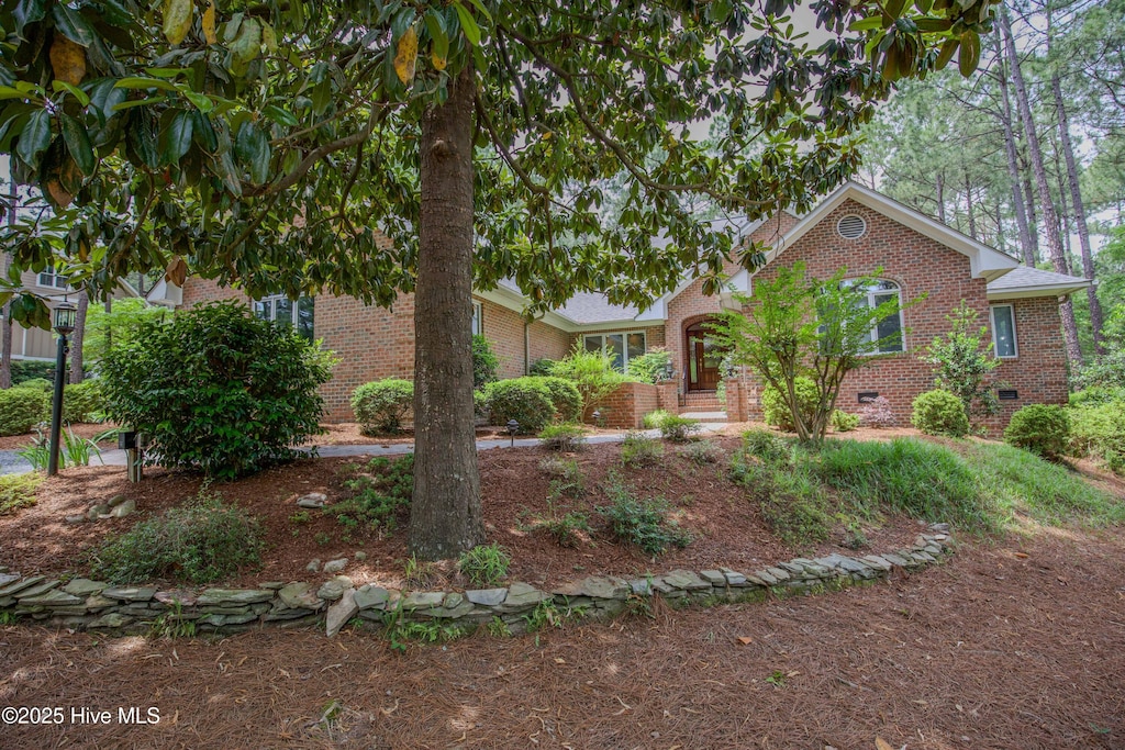 view of front facade featuring brick siding and crawl space