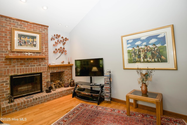 17 Troon Dr, Pinehurst, NC 28374 - living area with a brick fireplace, wood finished floors, lofted ceiling, baseboards, and recessed lighting