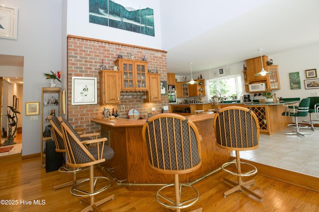 17 Troon Dr, Pinehurst, NC 28374 - bar with white microwave, a high ceiling, light wood-style flooring, decorative light fixtures, and stainless steel oven