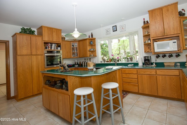 17 Troon Dr, Pinehurst, NC 28374 - kitchen with open shelves, oven, white microwave, a center island, and a kitchen breakfast bar