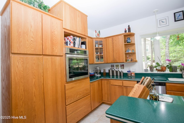 17 Troon Dr, Pinehurst, NC 28374 - kitchen with appliances with stainless steel finishes, open shelves, light tile patterned floors, hanging light fixtures, and glass insert cabinets