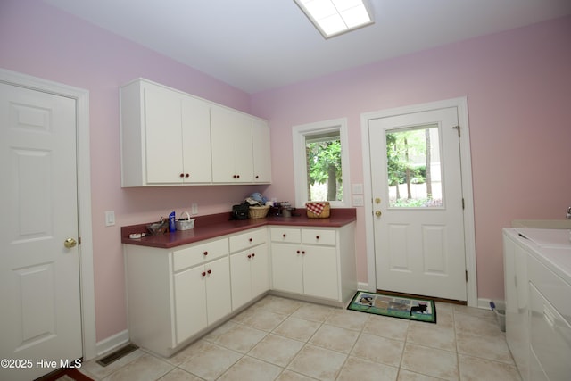 17 Troon Dr, Pinehurst, NC 28374 - washroom featuring cabinet space, baseboards, washing machine and clothes dryer, and light tile patterned floors