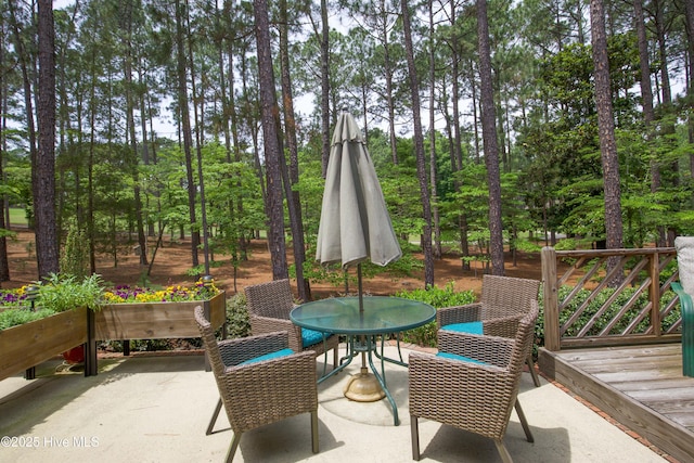 17 Troon Dr, Pinehurst, NC 28374 - view of patio / terrace with outdoor dining area, view of wooded area, and a deck
