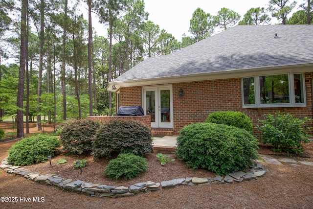 17 Troon Dr, Pinehurst, NC 28374 - view of side of home with roof with shingles, brick siding, and french doors