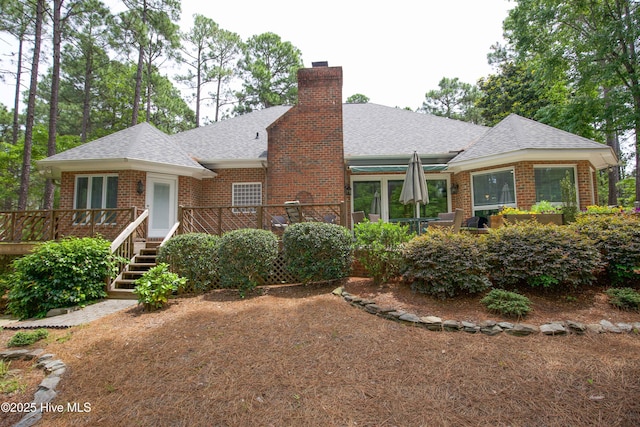 17 Troon Dr, Pinehurst, NC 28374 - view of front of home featuring roof with shingles, brick siding, a chimney, and a deck