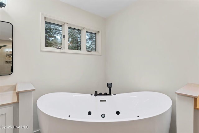 full bath with a soaking tub and vanity