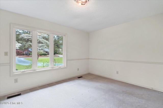 carpeted spare room with baseboards and a textured ceiling