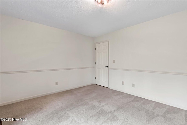 unfurnished room featuring carpet, baseboards, and a textured ceiling