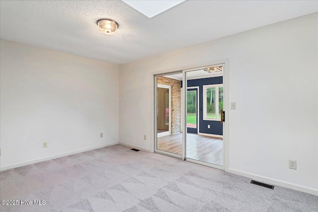 spare room with carpet floors, baseboards, and a textured ceiling