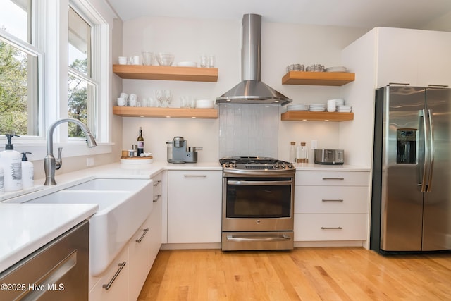 3 Sabal Palm Trl, Bald Head Island, NC 28461 - kitchen featuring stainless steel appliances, wall chimney exhaust hood, a sink, open shelves, and light wood-style floors