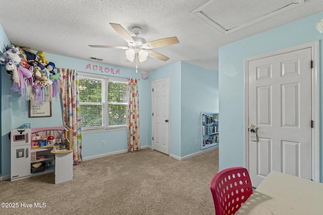 carpeted bedroom featuring attic access, baseboards, a textured ceiling, and a ceiling fan