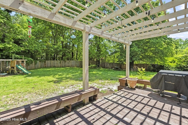 deck featuring a pergola, a playground, view of scattered trees, and a grill