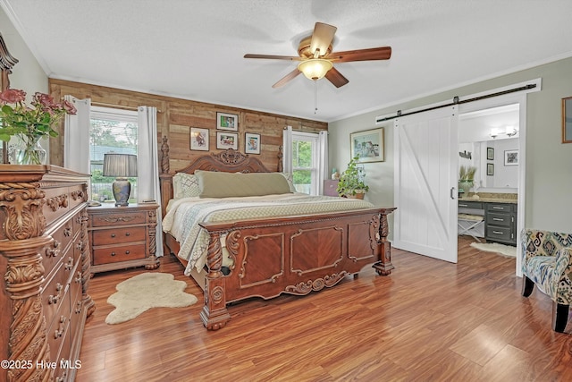 4713 Crosswinds Dr, Wilmington, NC 28409 - bedroom with a barn door, multiple windows, ornamental molding, and wood finished floors
