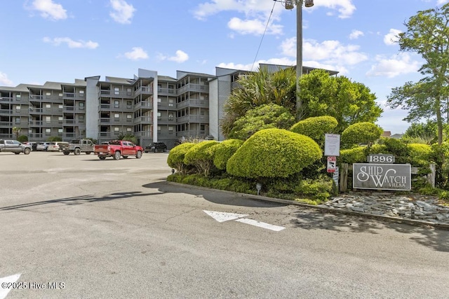 view of apartment building / complex with uncovered parking