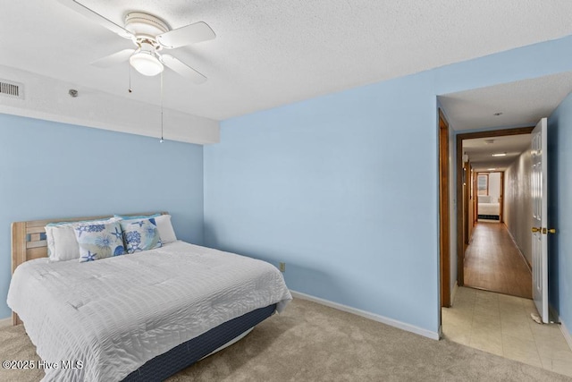 carpeted bedroom with baseboards, a ceiling fan, and a textured ceiling