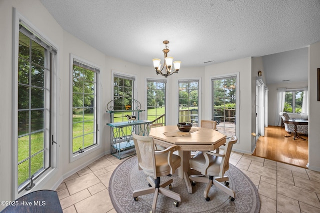 9333 Doris Dr, Oriental, NC 28571 - sunroom featuring plenty of natural light, a chandelier, a textured ceiling, and baseboards