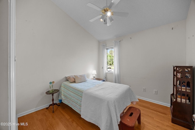 9333 Doris Dr, Oriental, NC 28571 - bedroom featuring baseboards, light wood-style floors, lofted ceiling, ceiling fan, and a textured ceiling