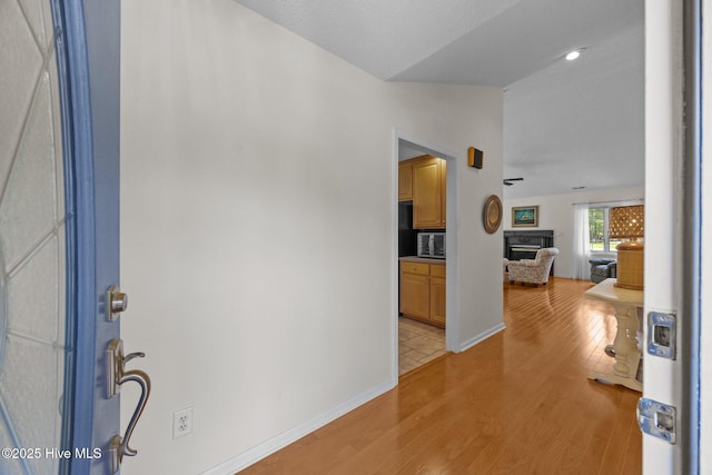 9333 Doris Dr, Oriental, NC 28571 - foyer with vaulted ceiling, a fireplace, light wood-type flooring, and baseboards