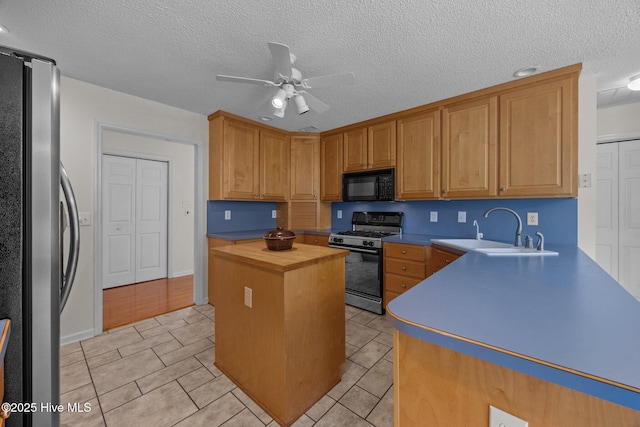 9333 Doris Dr, Oriental, NC 28571 - kitchen with gas range oven, freestanding refrigerator, black microwave, a sink, and wooden counters