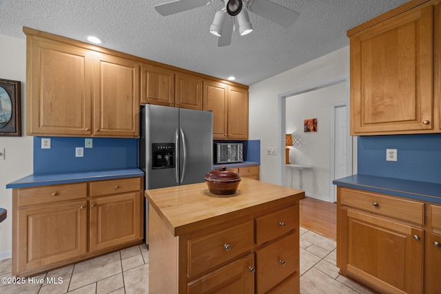 9333 Doris Dr, Oriental, NC 28571 - kitchen with butcher block counters, stainless steel fridge with ice dispenser, light tile patterned floors, ceiling fan, and a textured ceiling