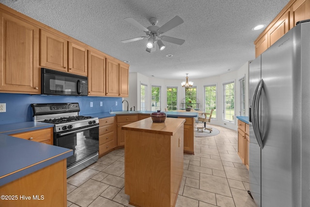 9333 Doris Dr, Oriental, NC 28571 - kitchen with stainless steel refrigerator with ice dispenser, black microwave, gas stove, a peninsula, and a sink