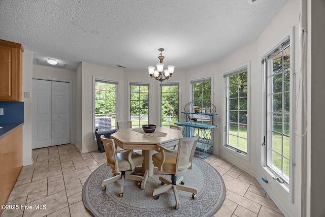 9333 Doris Dr, Oriental, NC 28571 - dining space featuring plenty of natural light, a chandelier, light tile patterned floors, and a textured ceiling