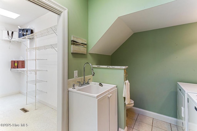 20 Shenecossett Ln, Pinehurst, NC 28374 - bathroom featuring washing machine and clothes dryer, vanity, toilet, baseboards, and a skylight