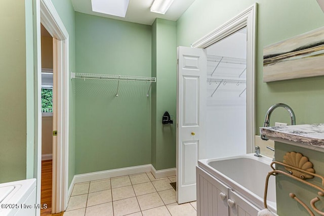 20 Shenecossett Ln, Pinehurst, NC 28374 - washroom featuring cabinet space, light tile patterned floors, baseboards, and a skylight