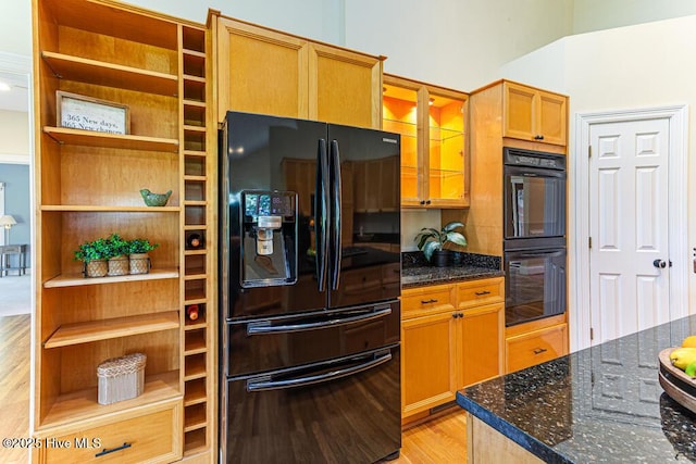 20 Shenecossett Ln, Pinehurst, NC 28374 - kitchen featuring black appliances, light wood-style flooring, dark stone countertops, glass insert cabinets, and open shelves