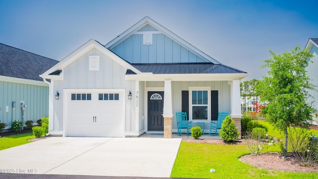 view of front of house with covered porch, board and batten siding, a garage, a standing seam roof, and concrete driveway