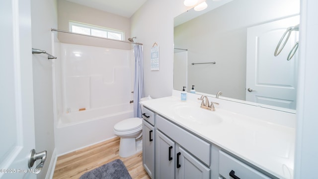 full bath with wood finished floors, vanity, toilet, and shower / bath combo with shower curtain
