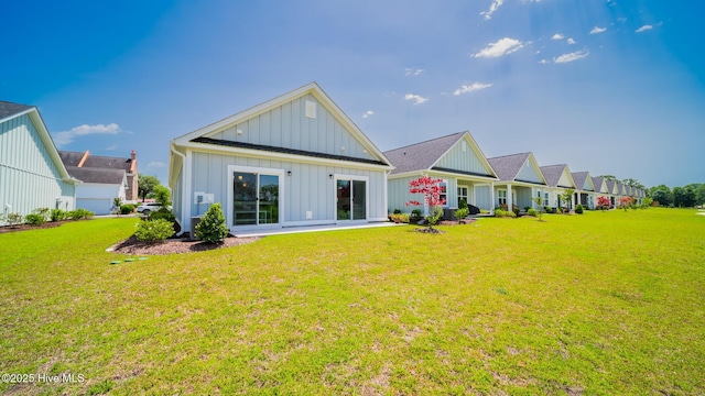 rear view of property with board and batten siding and a lawn