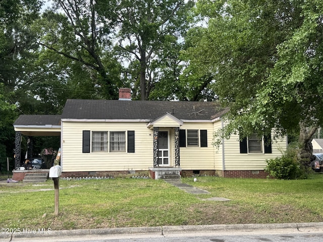 view of front of home featuring crawl space, a front lawn, and a chimney