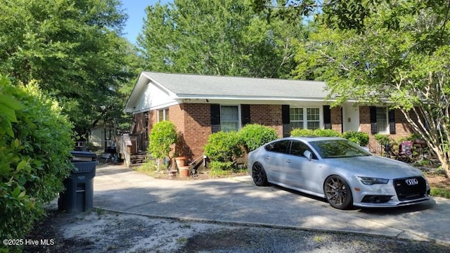 single story home featuring brick siding and driveway