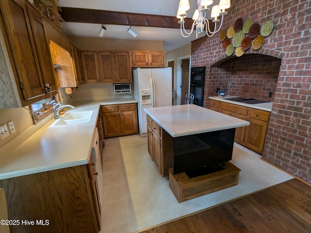 kitchen featuring black appliances, a sink, open shelves, light countertops, and brown cabinetry