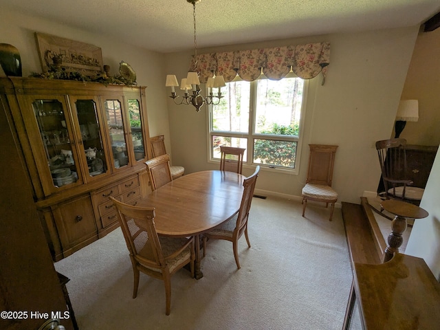dining space with light colored carpet, a chandelier, and a textured ceiling