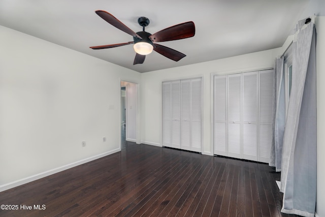 107 Live Oak Ct, Pine Knoll Shores, NC 28512 - unfurnished bedroom featuring two closets, hardwood / wood-style flooring, baseboards, and ceiling fan