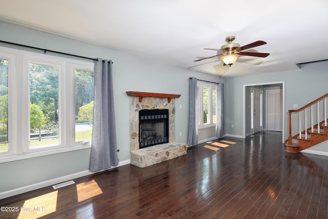 107 Live Oak Ct, Pine Knoll Shores, NC 28512 - unfurnished living room with stairway, a stone fireplace, baseboards, ceiling fan, and wood-type flooring