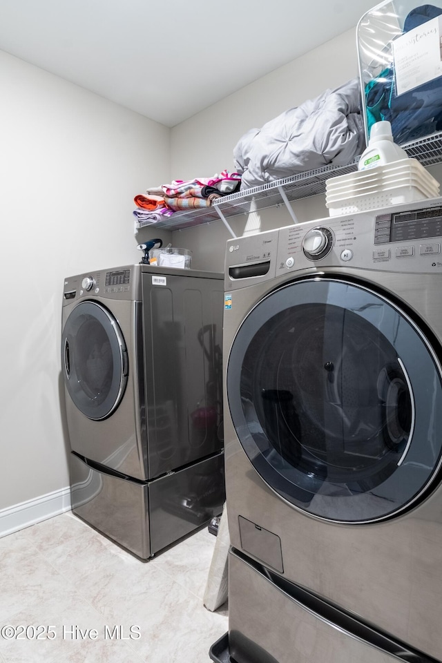 clothes washing area featuring washer and dryer and baseboards